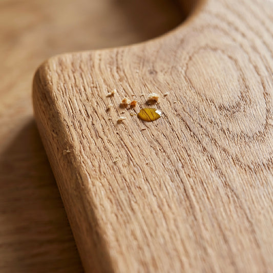 Detailaufnahme eines handgefertigten Servierbretts aus massiver Eiche mit natürlicher Holzmaserung und hochwertig geölter Oberfläche.
