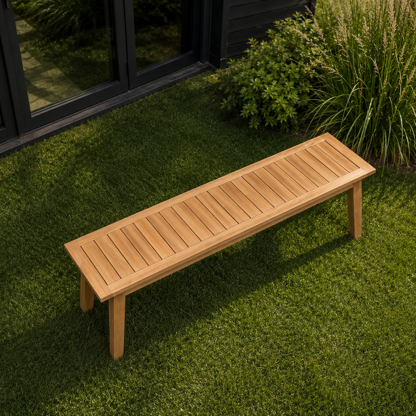 Draufsicht auf die Gartenbank Terra aus massiver Eiche mit Lamellen-Sitzfläche und schrägen Holzbeinen. Moderne Sitzbank aus Eichenholz auf grünem Rasen im minimalistischen Outdoor-Bereich.