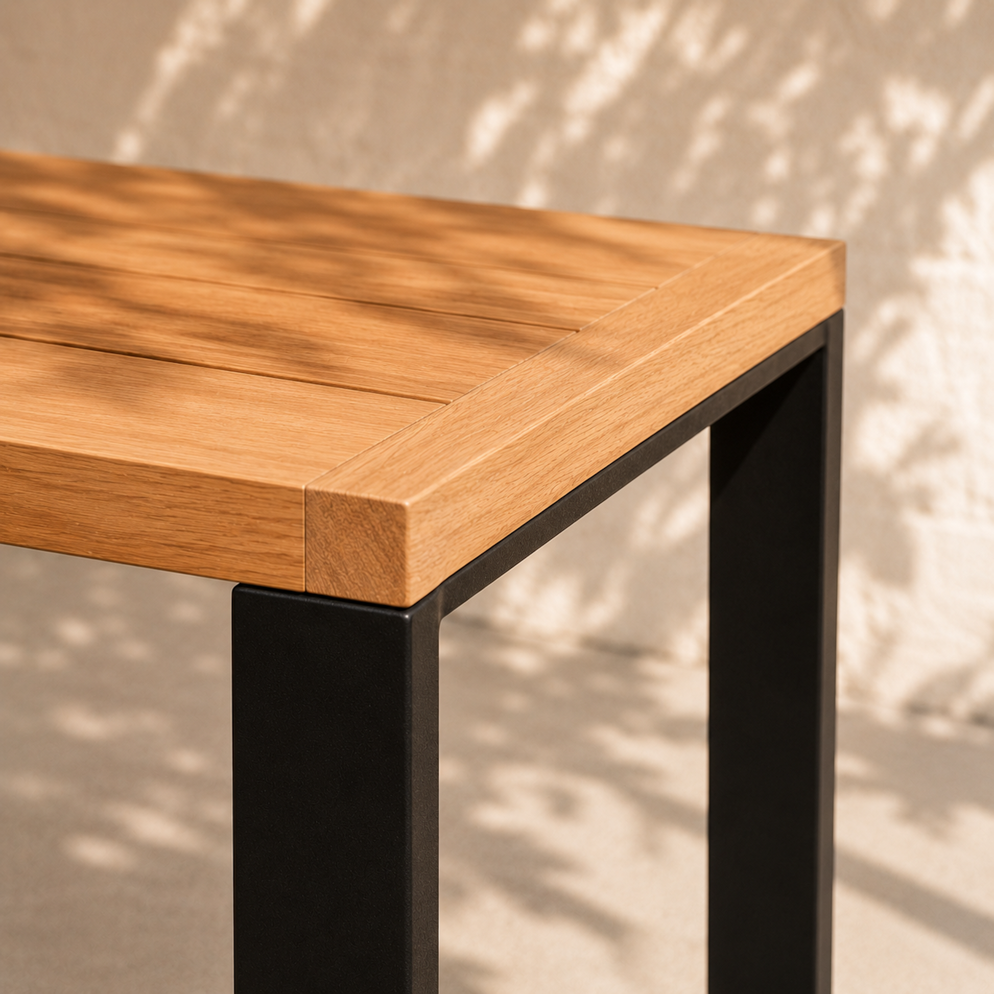 Nahaufnahme des Gartentischs Urban aus massiver Eiche mit schwarzer Stahlkufe und hochwertiger Holzmaserung. Moderner Outdoor-Esstisch aus Eichenholz mit minimalistischer Tischplatte und pulverbeschichtetem Metallgestell.