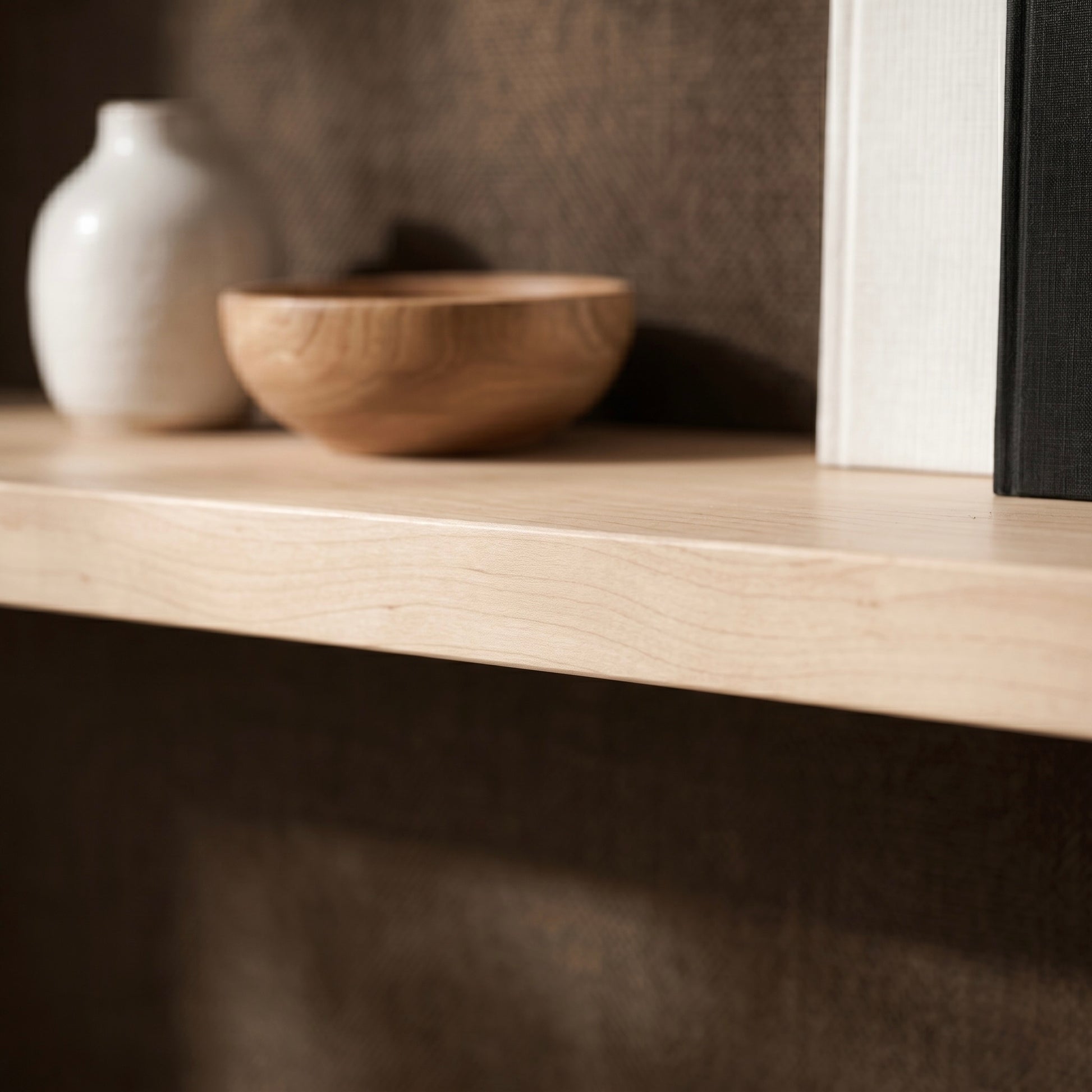 Nahaufnahme eines schwebenden Wandregals ECO aus Ahornfurnier mit heller Holzmaserung, dekoriert mit Keramikvase und Holzschale, modernes Wandregal mit verdeckter Befestigung.