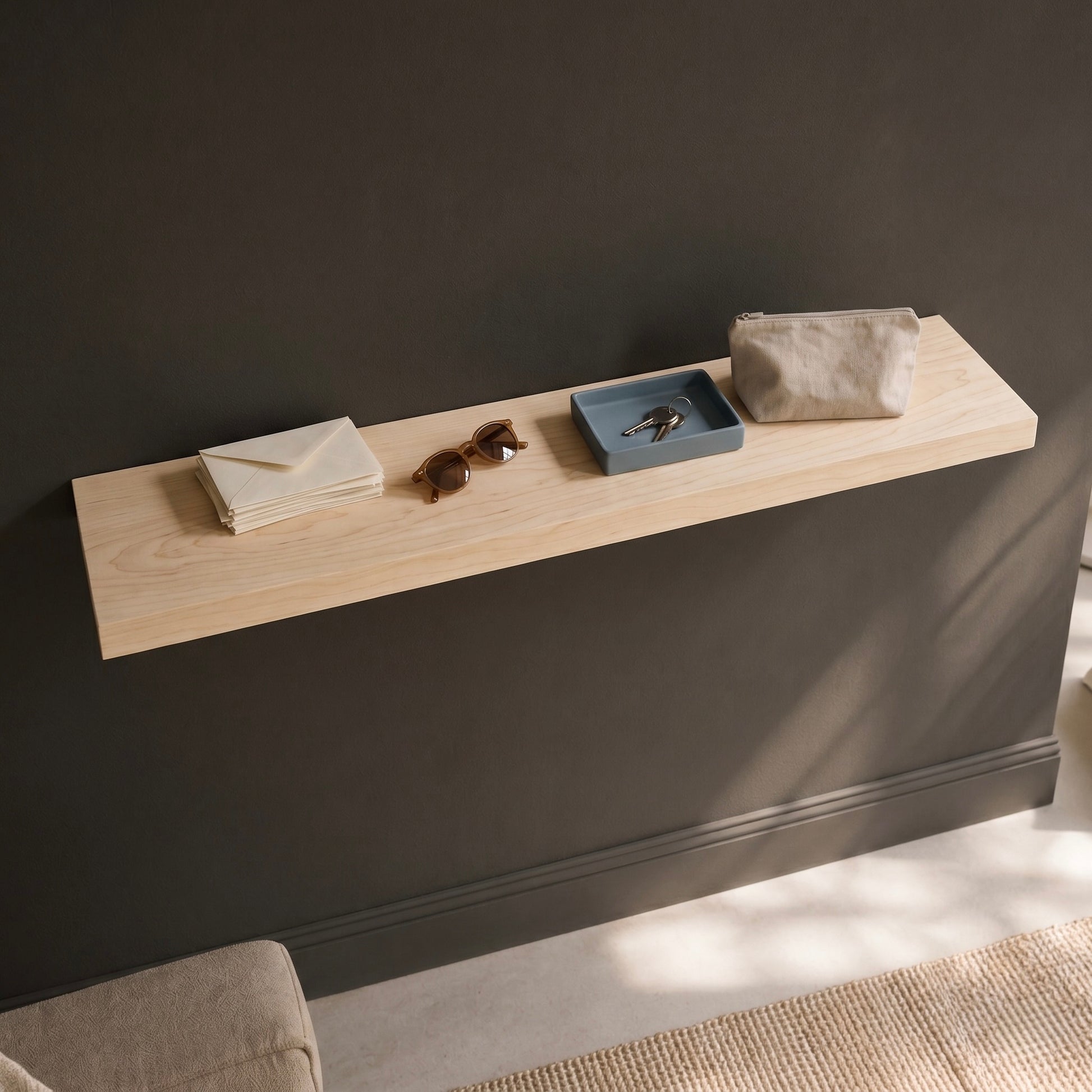 Schwebendes Wandregal aus Ahorn Massivholz an dunkler Wand mit Schlüsseln, Sonnenbrille und minimalistischer Dekoration im modernen Wohnstil bei natürlichem Tageslicht