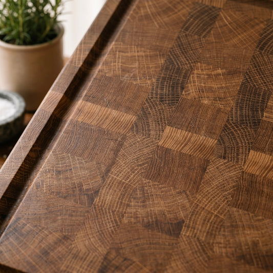 Detailaufnahme eines Stirnholz-Schneidebretts aus Eiche mit markanter Endgrain-Maserung und eingefräster Saftrille. Warme Holzfarben und hochwertige Oberfläche im Fokus.