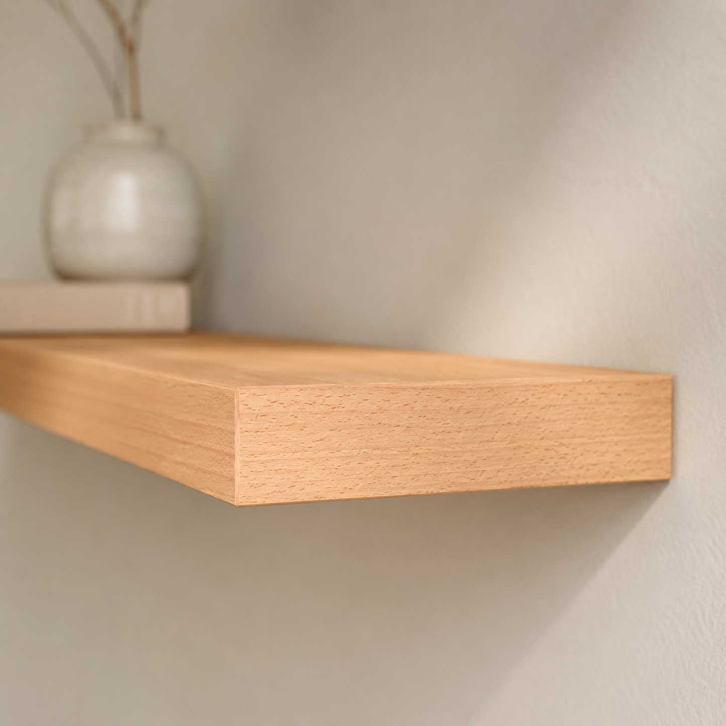 Schwebendes Wandboard ECO aus furnierter Buche in einem hellen, minimalistischen Wohnraum. Die warme Holzoberfläche harmoniert mit einer Keramikvase und einem Buch und unterstreicht die klare, zeitlose Gestaltung des Regals.