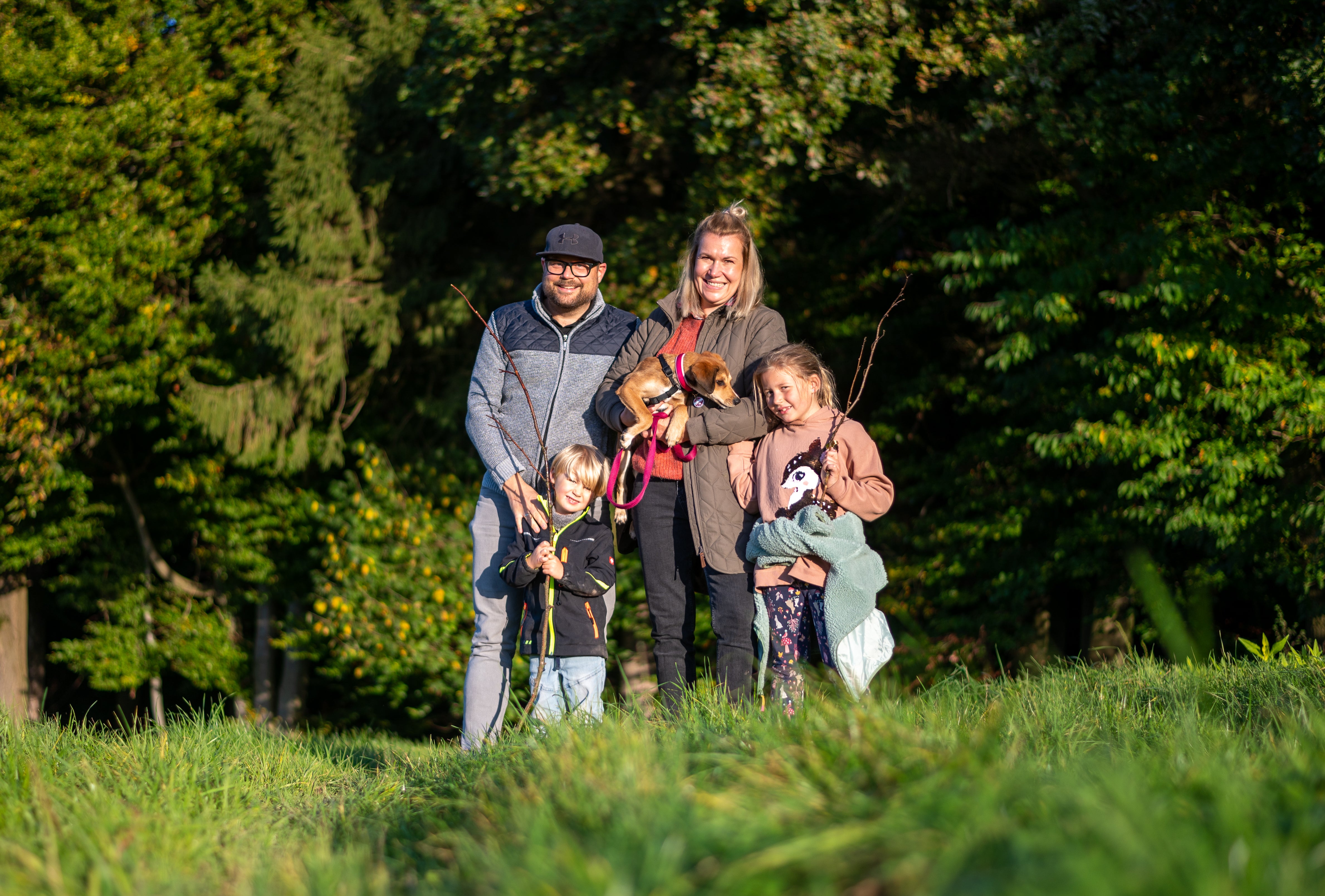 Familie Schnee von Planet Tree steht gemeinsam im Grünen als Teil der Aufforstungsarbeit und Baumpflanzung