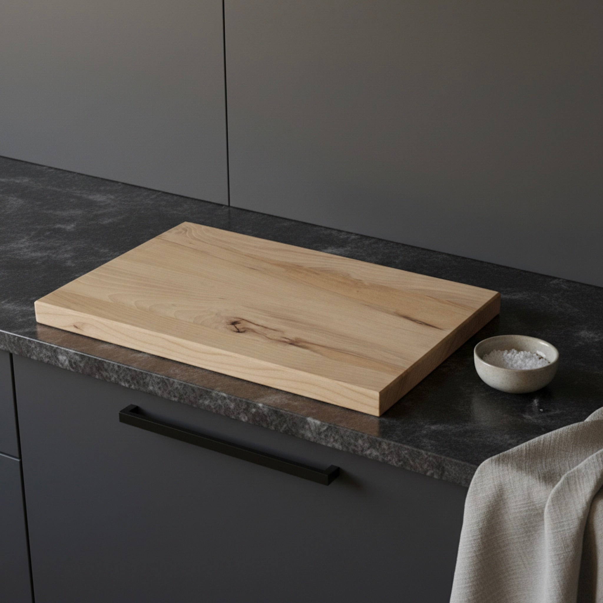 Schneidebrett aus massiver Buche, liegend auf dunkler Küchenarbeitsplatte