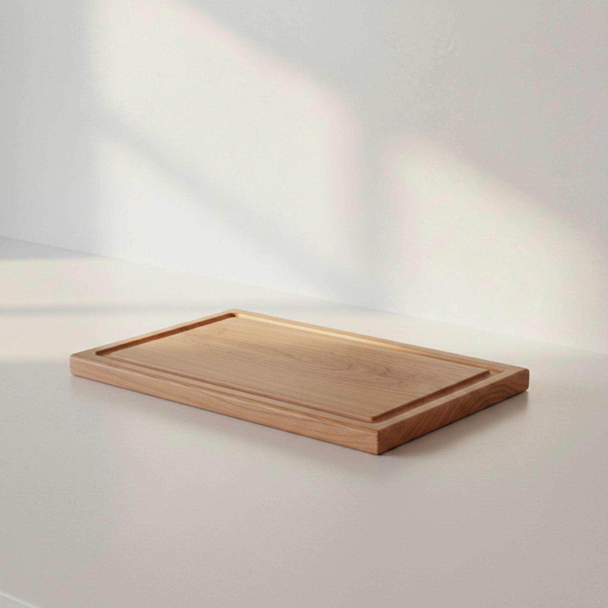 Schneidebrett aus massivem Kirschbaum mit Saftrille in minimalistischem Setting