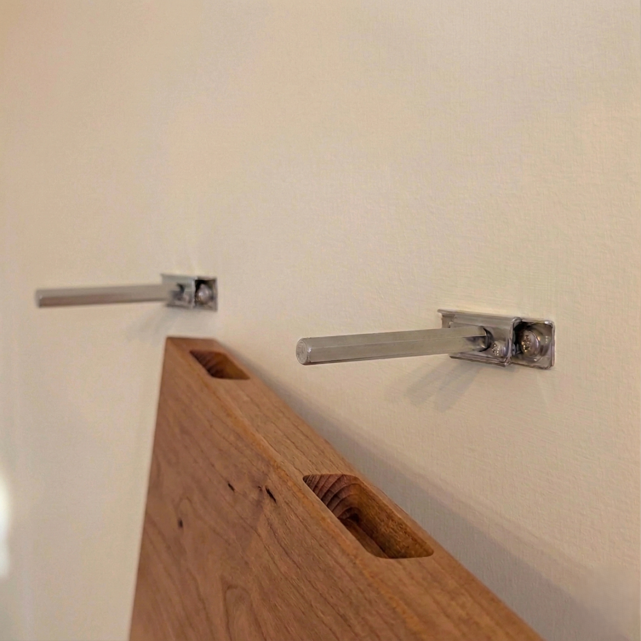 Schwebendes Wandregal aus Kirschbaum Massivholz mit stabiler unsichtbarer Metallhalterung zur Wandmontage.