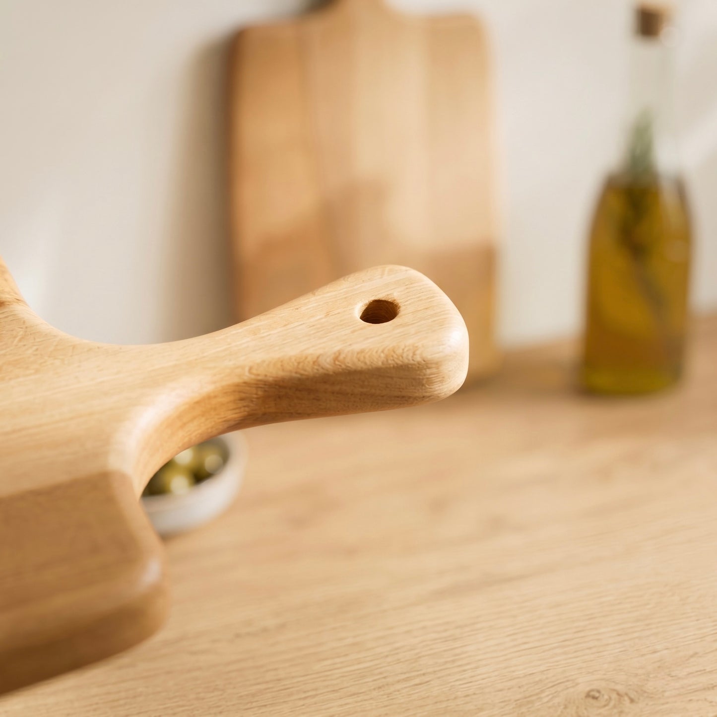 Detailaufnahme des ergonomischen Griffs mit Aufhängeloch am Servierbrett Buche Artisan aus Massivholz