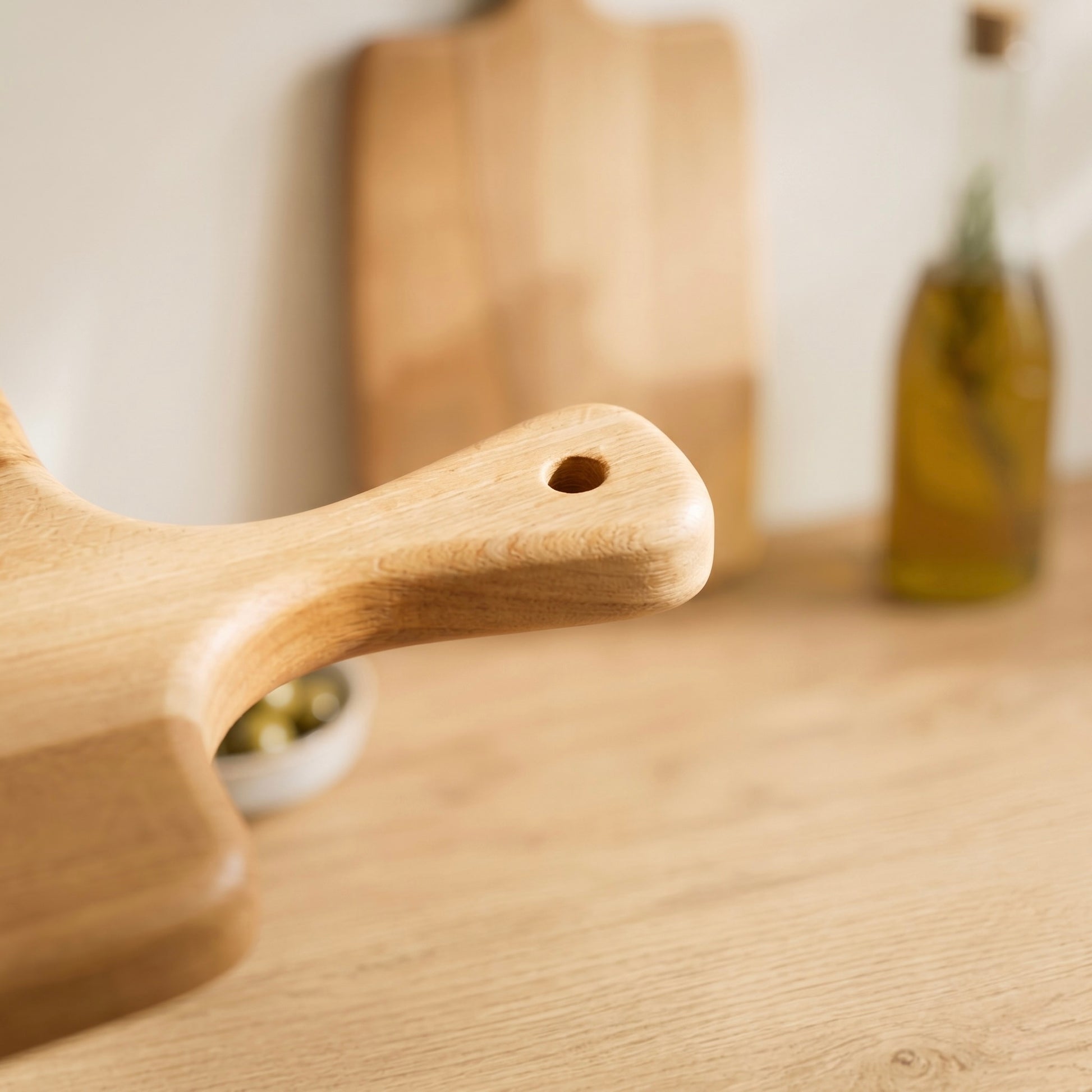 Detailaufnahme des ergonomischen Griffs mit Aufhängeloch am Servierbrett Buche Artisan aus Massivholz