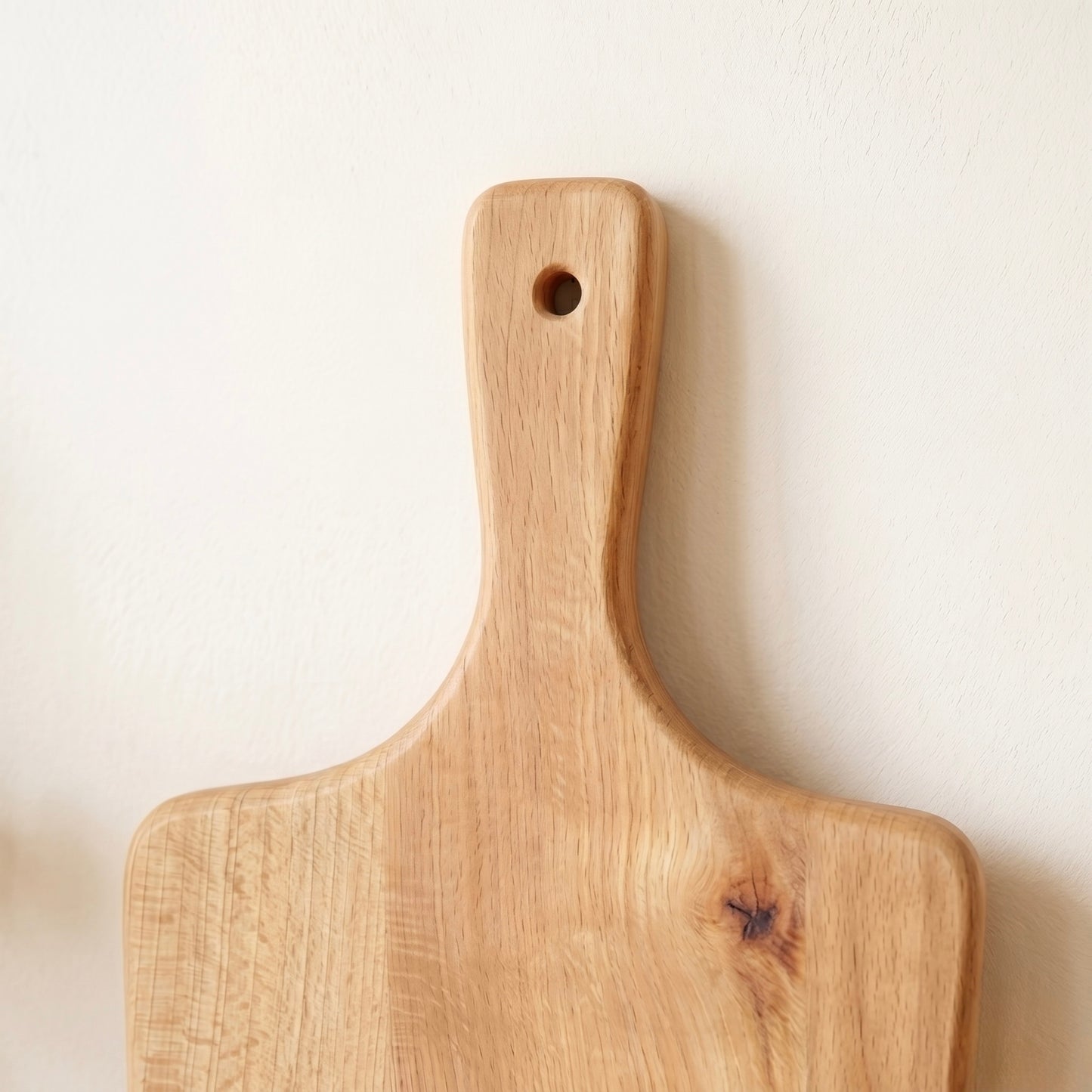 Detailaufnahme des ergonomischen Griffs mit Aufhängeloch am Servierbrett Buche Pure aus Massivholz
