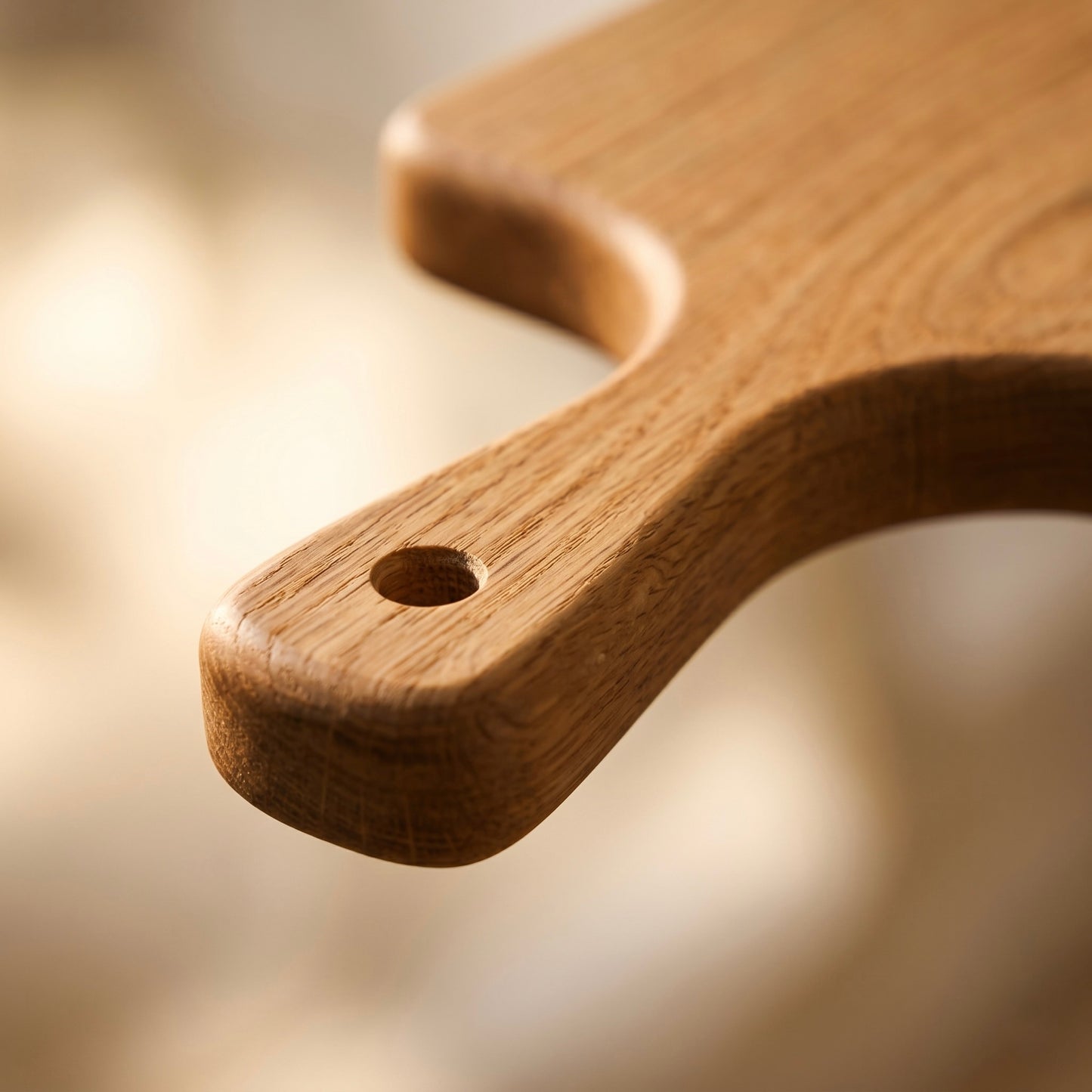 Detailaufnahme des ergonomischen Griffs mit Aufhängeloch am Servierbrett Eiche Pure aus Massivholz