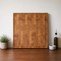 Handgefertigtes Stirnholz-Schneidebrett aus massiver Lärche mit Saftrille in moderner, natürlicher Küchenatmosphäre mit warmer Holzoptik.