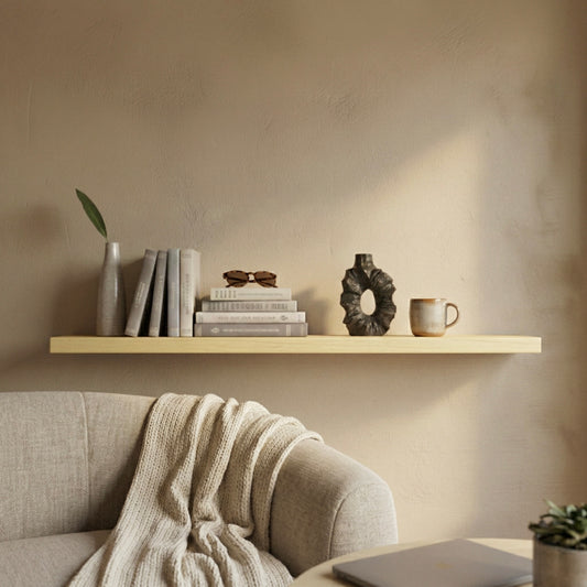 Schwebendes Wandregal aus Birke in einem warmen Wohnzimmer mit Büchern, Vase und Keramik, über einem Sofa dekoriert