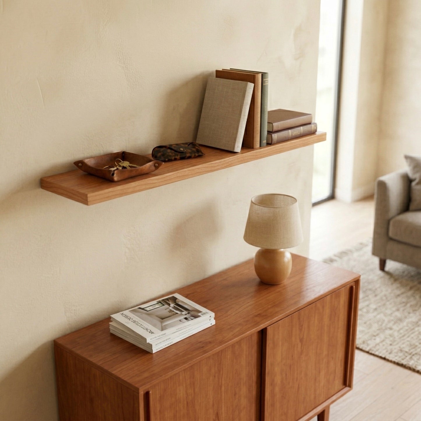 Schwebendes Wandregal aus Kirschbaum furniert über Sideboard mit Büchern, Schale und Lampe in warmem Wohnzimmer