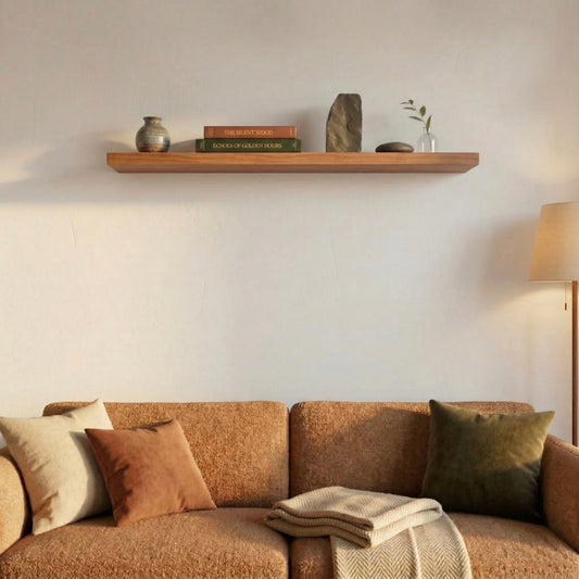 Schwebendes Wandregal aus Kirschbaum über Sofa in warmem Wohnzimmer mit Büchern und Deko