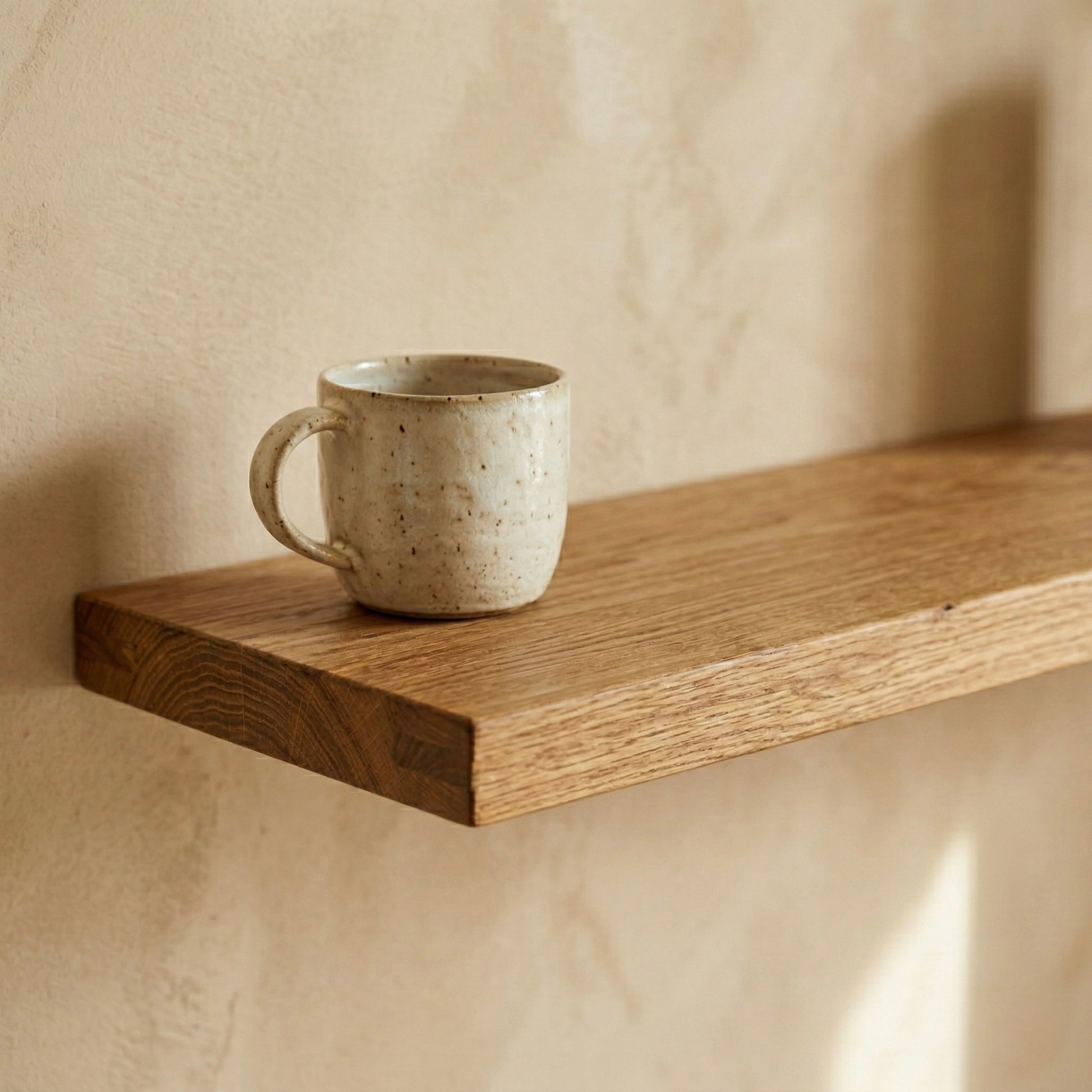 Minimalistisches schwebendes Wandregal aus Rüster mit Tasse in warmem, ruhigem Licht und klarer Holzstruktur