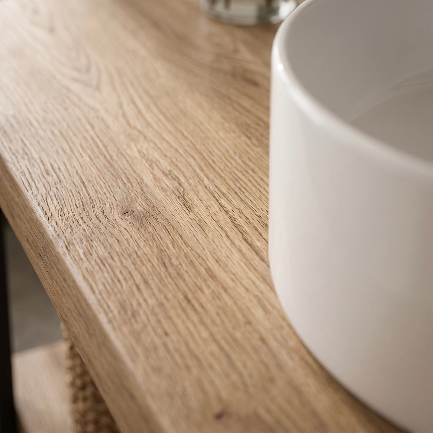 Detailaufnahme der Eichenholzoberfläche des Linea Loft Base Solo Waschtischs mit feiner Maserung neben weißem Aufsatzwaschbecken