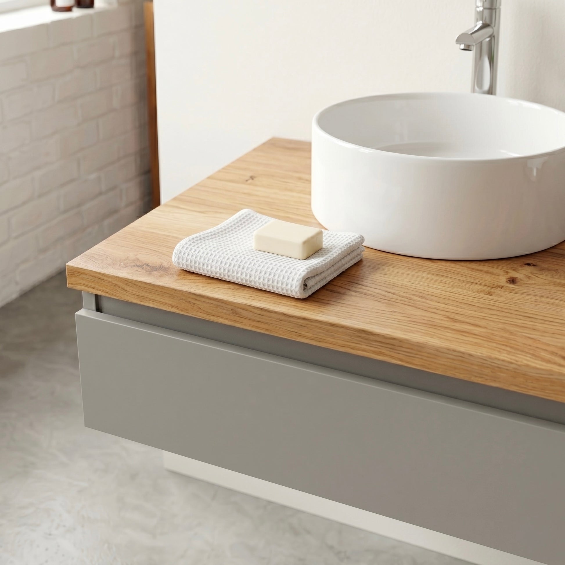 Detailaufnahme des Linea Soft Duo Waschtischs aus Eiche mit weißem Aufsatzwaschbecken, Holzplatte und minimalen Badaccessoires in hellem Badezimmer